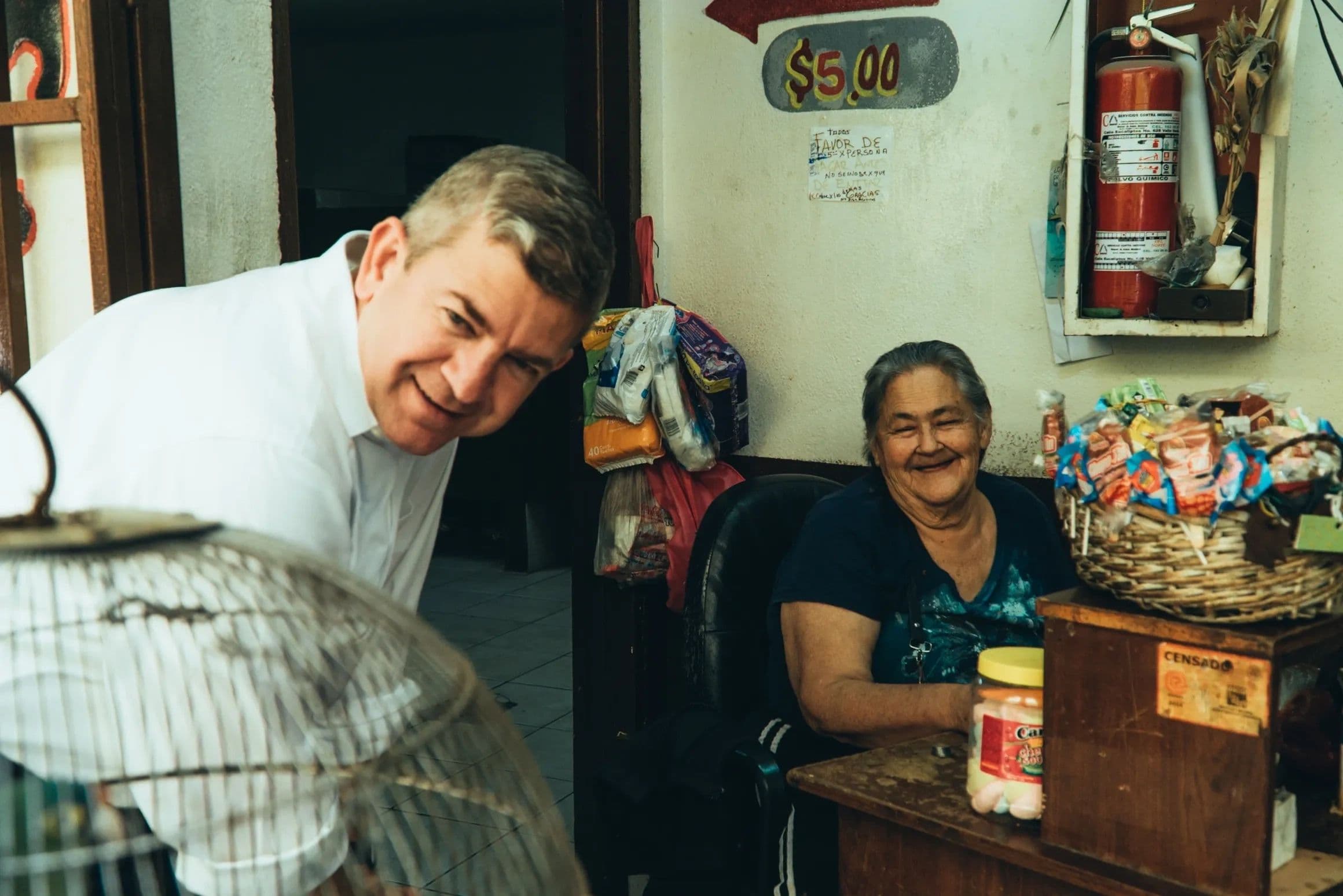 Oscar Vega Marín conversa con una comerciante en su local