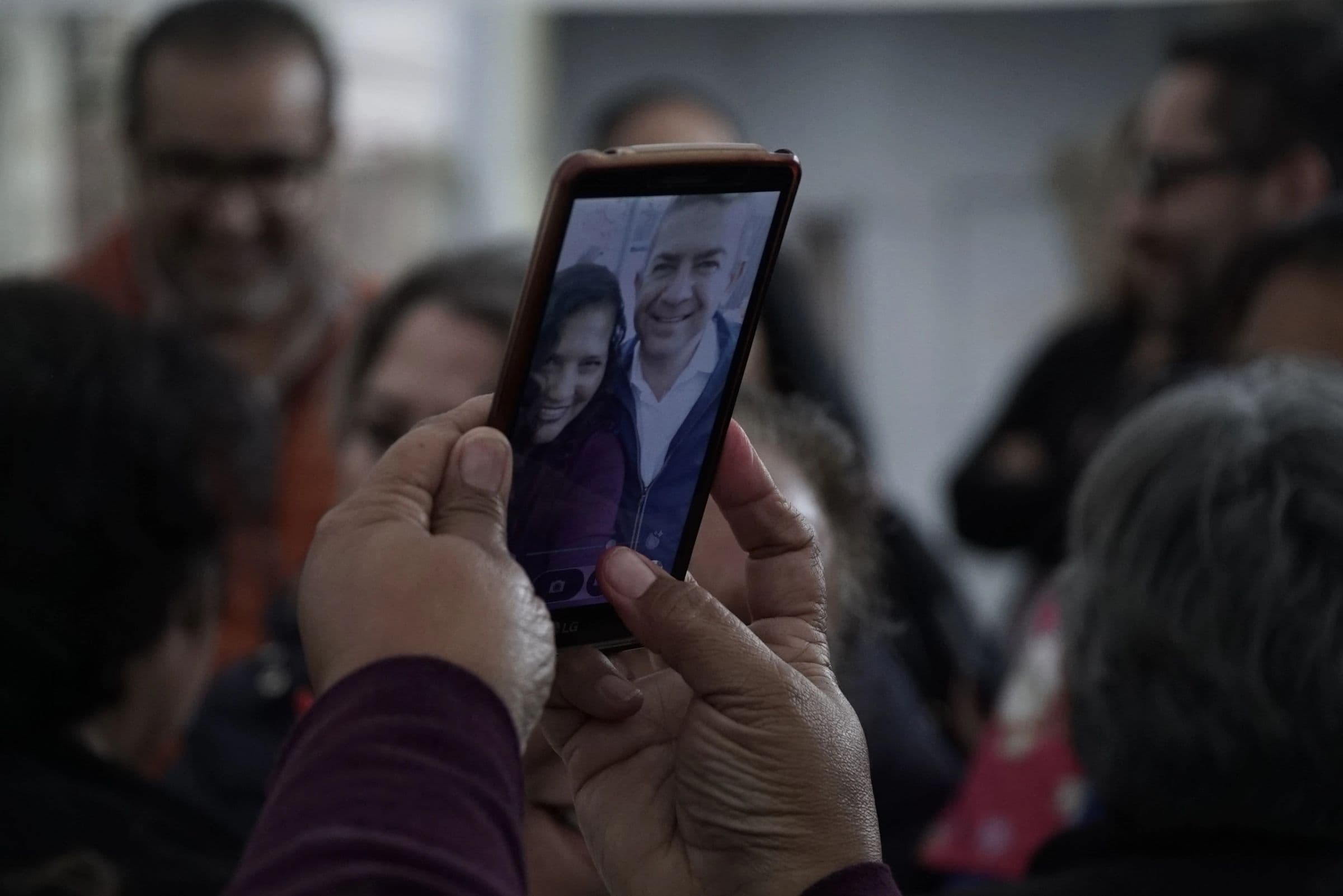 Una persona fotografía a Oscar Vega Marín con su teléfono
