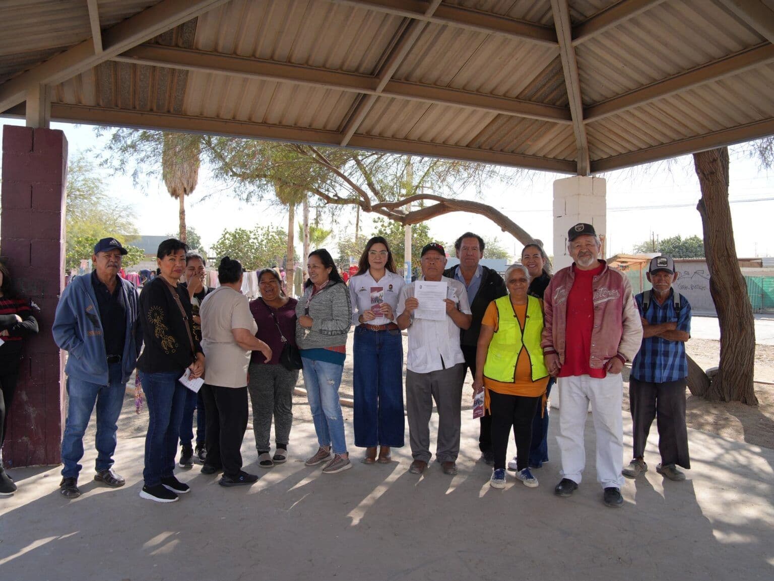 Vecinos y personal municipal reunidos bajo una palapa